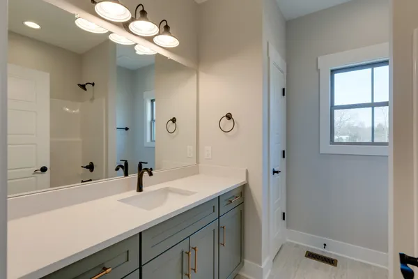 a bathroom with a sink a light fixture and a mirror