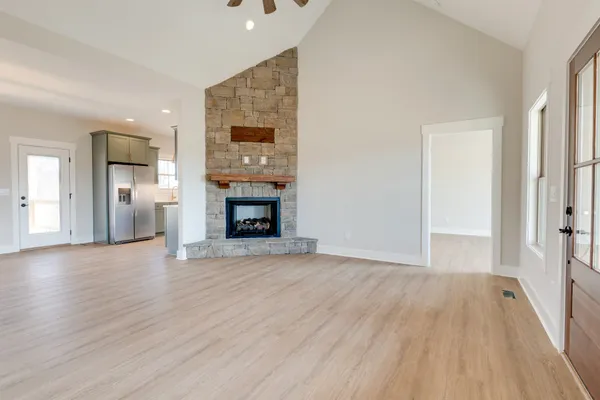 a view of empty room with wooden floor and fireplace