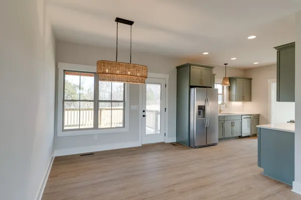 a view of a kitchen with refrigerator and wooden floor