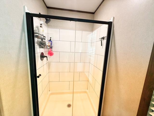 36469 1330th Road Wewoka, OK 74884 - Photo 30 of 39 Shower enclosure with black-framed glass door, white rectangular wall tiles, and dark bronze fixtures