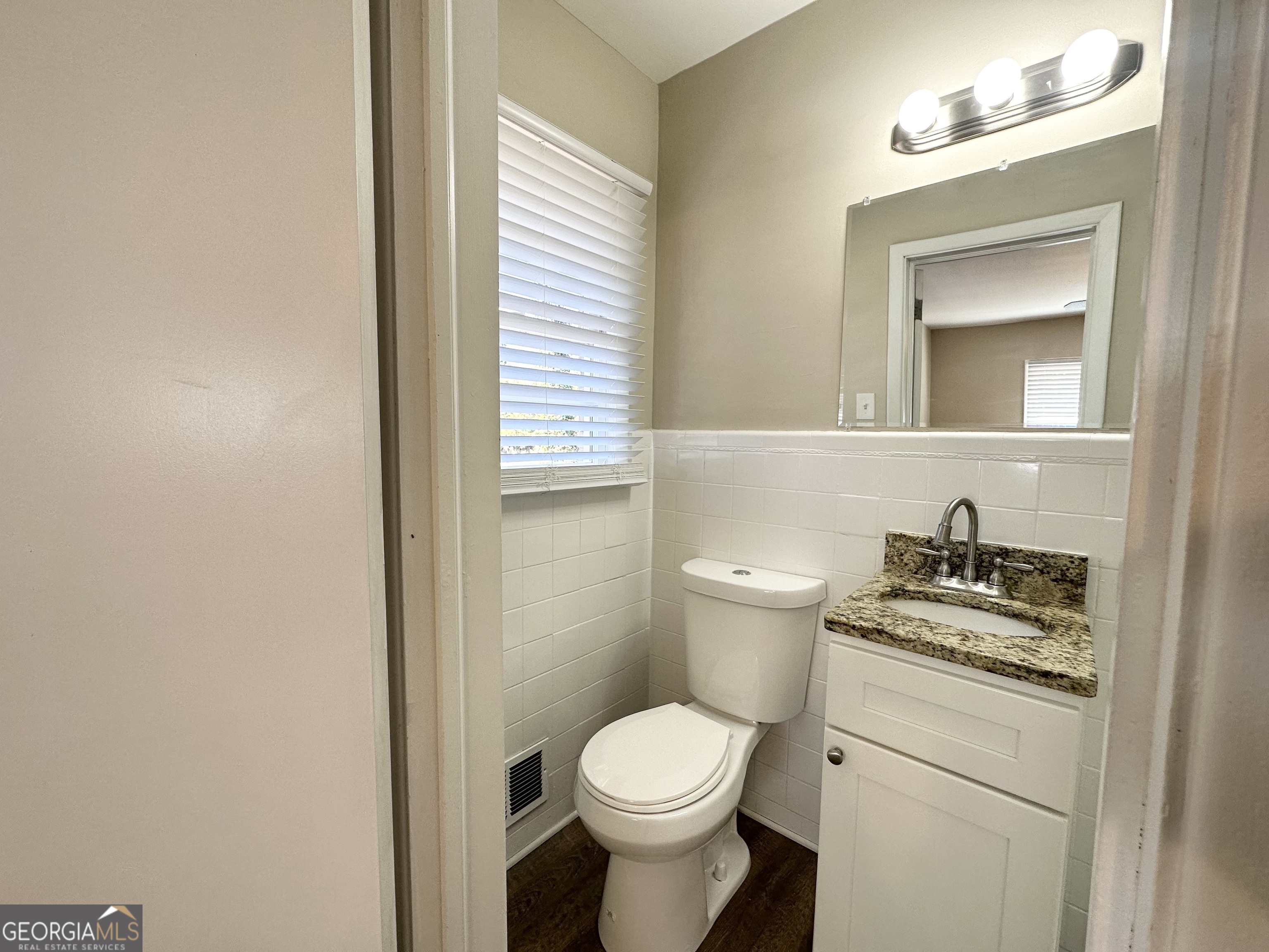 2896 Hogan Road East Point, GA 30344 - Photo 13 of 14 a bathroom with a granite countertop toilet sink and mirror