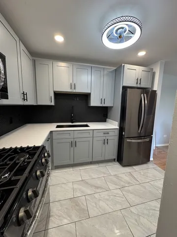 a kitchen with a stove a refrigerator and cabinets
