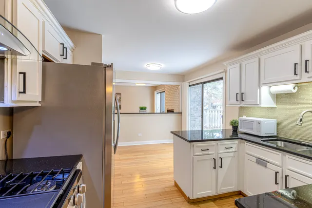 a kitchen with stainless steel appliances granite countertop a refrigerator and a stove