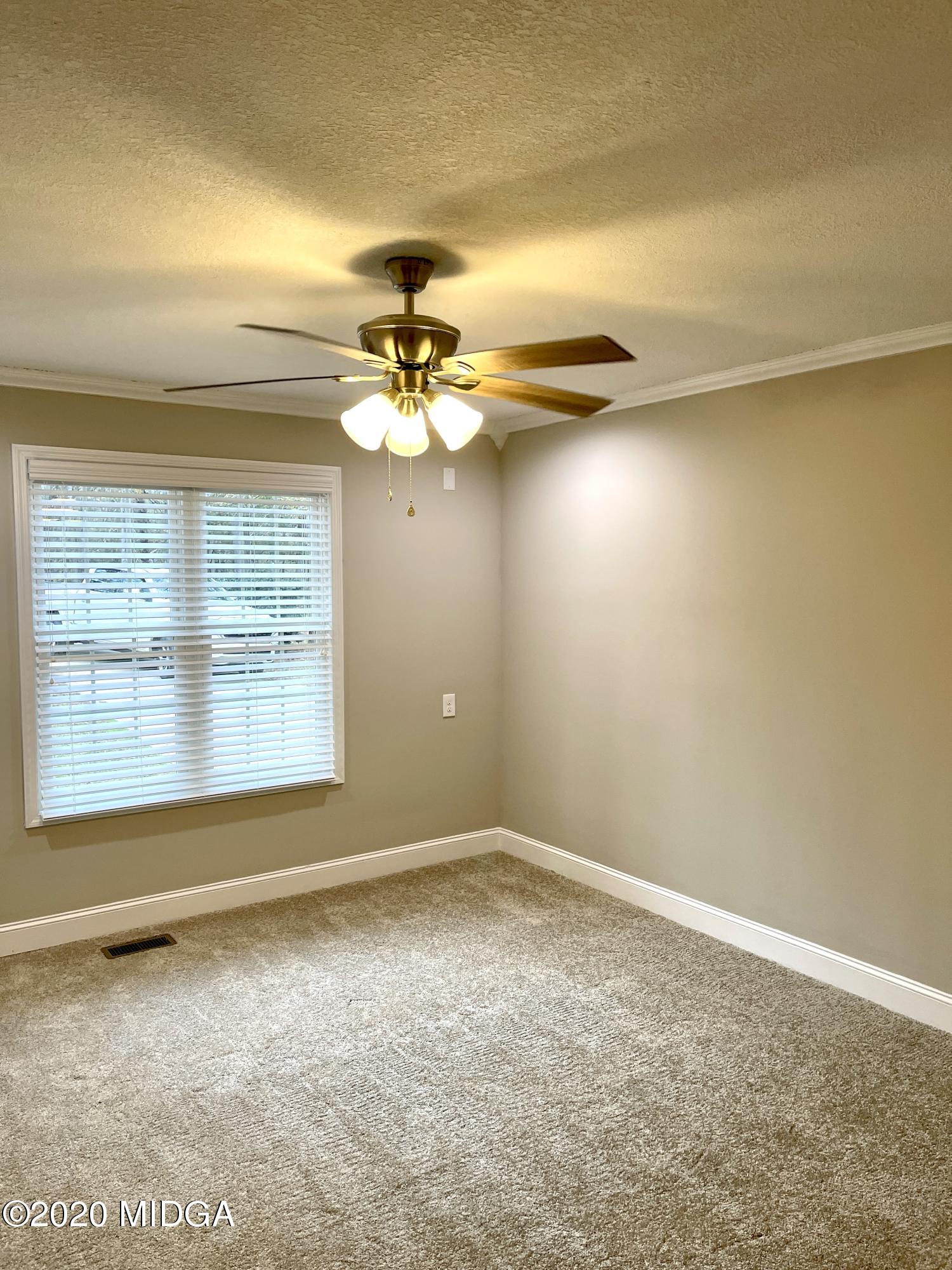 284 Klopfer Road Juliette, GA 31046 - Photo 9 of 15 an empty room with a chandelier fan and windows