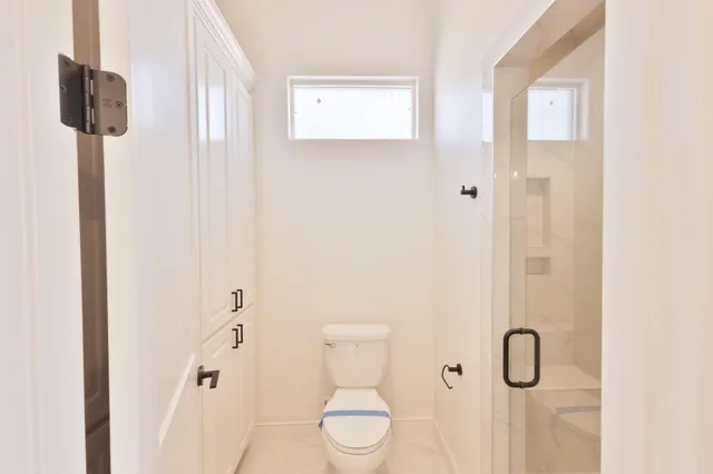 a bathroom with a toilet and a shower