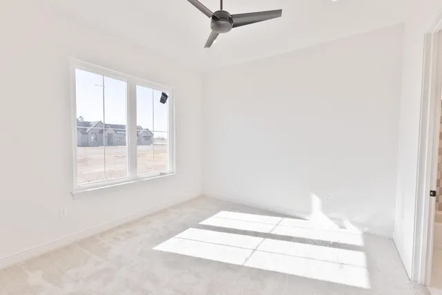 a white bed in a room next to a window