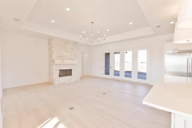 a view of an empty room with a fireplace and a window