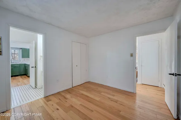 a view of a room with wooden floor and a hallway