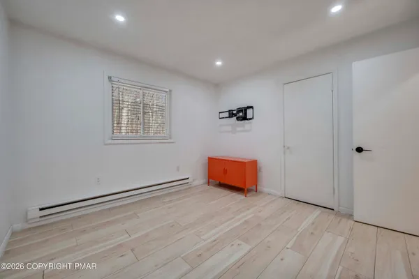 an empty room with wooden floor and windows