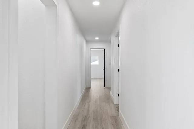 a view of a hallway with wooden floor