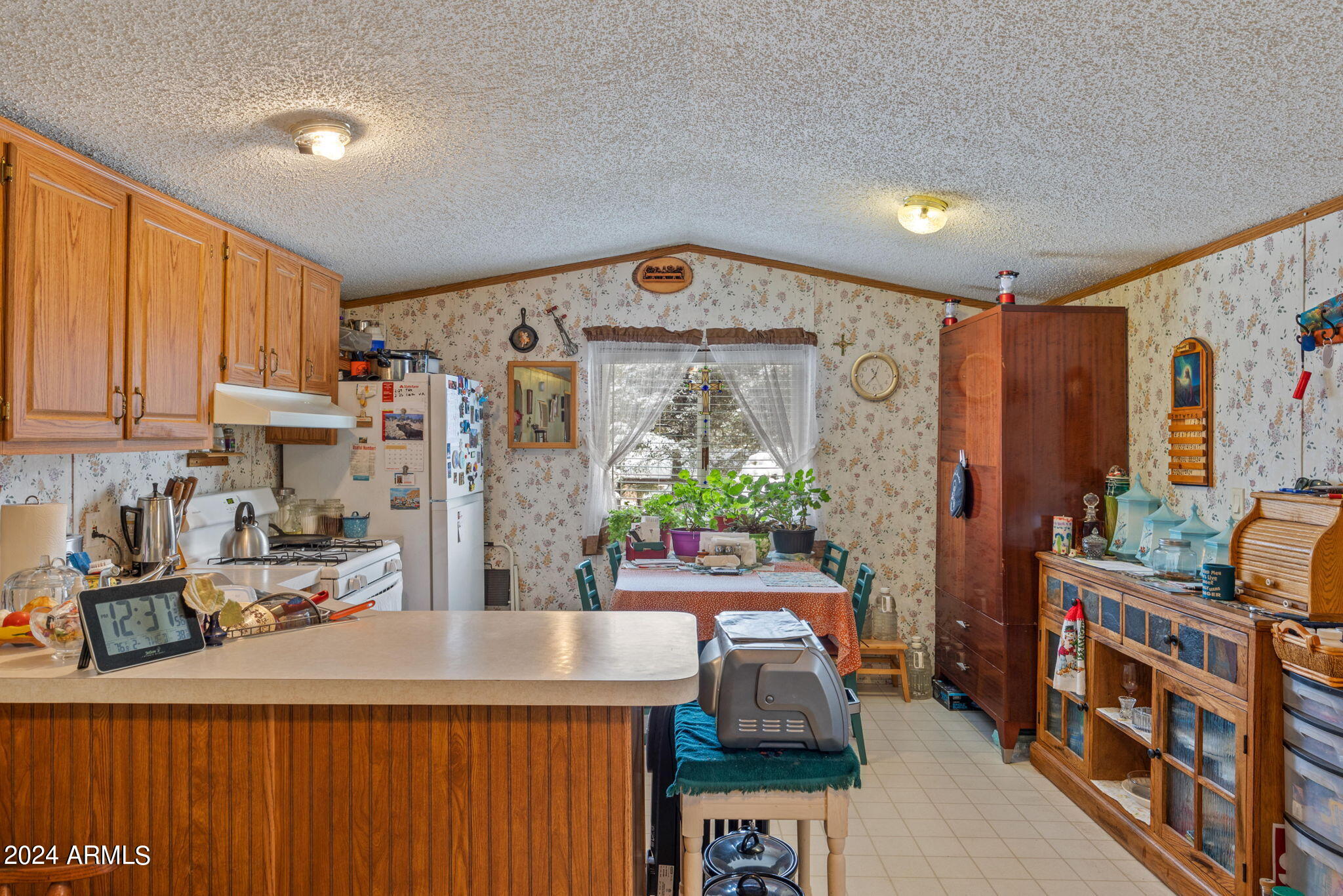 3512 Quail Run Road Overgaard, AZ 85933 - Photo 10 of 30 a kitchen with stainless steel appliances a sink a stove a refrigerator cabinets and a dining table