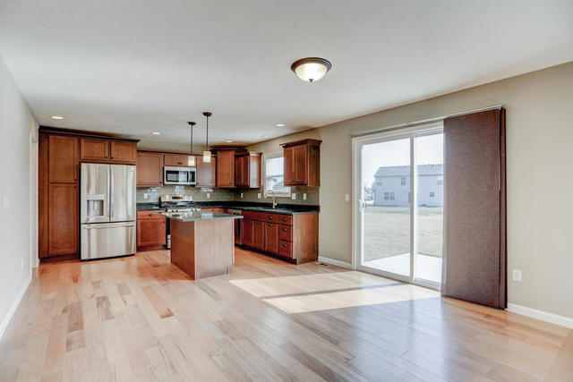 2003 Rylan Road Mahomet, IL 61853 - Photo 11 of 41 a kitchen with stainless steel appliances kitchen island granite countertop a refrigerator a sink a stove a dining table and chairs
