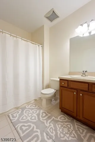 a bathroom with a double vanity sink toilet and a mirror