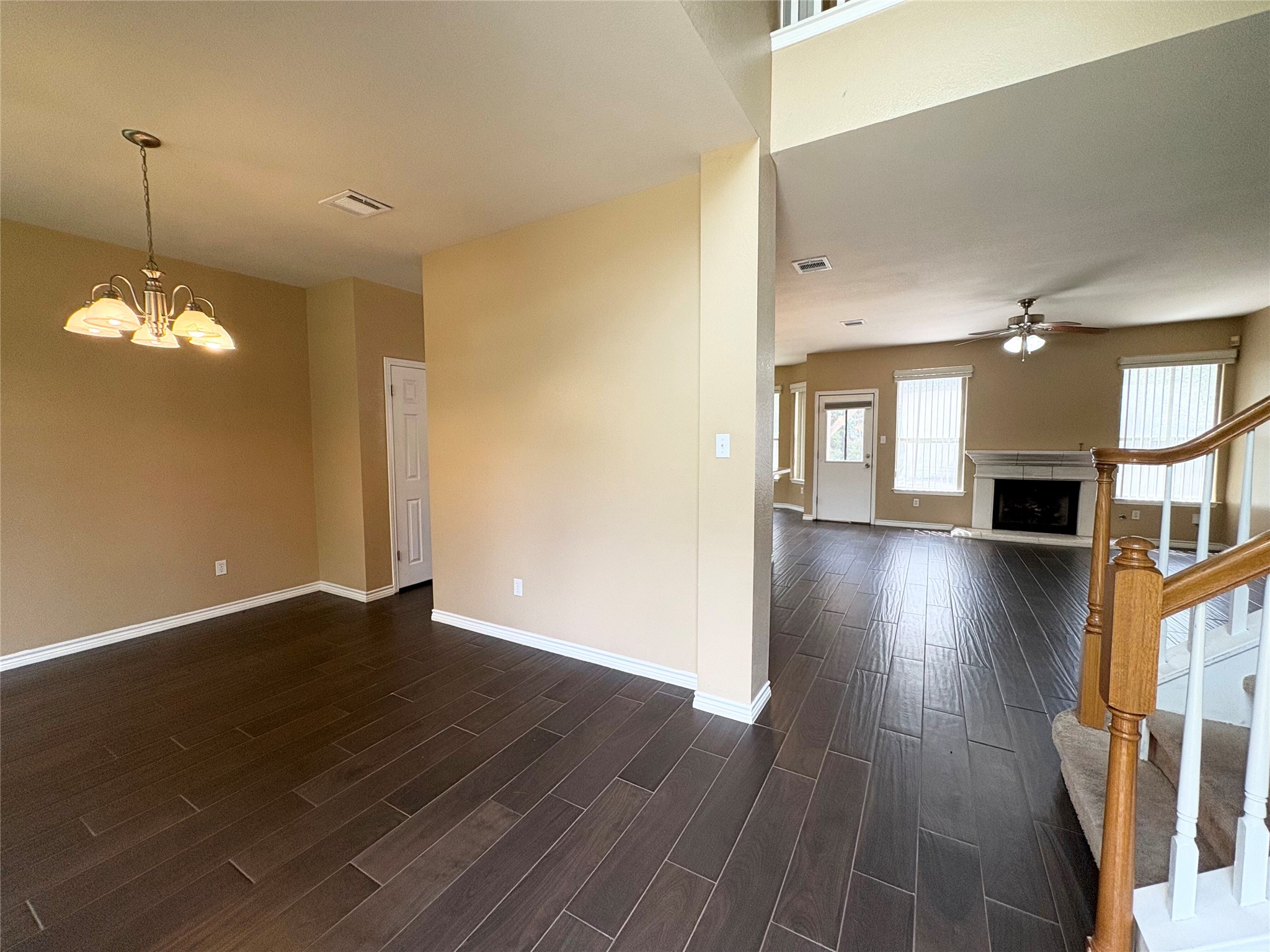 8103 Ephraim Road Austin, TX 78717 - Photo 4 of 35 Rich wood-look tile flooring connects the dining space to a welcoming living area with a fireplace and ceiling fan.