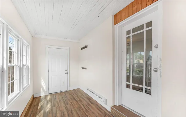 a view of a room with wooden floor and windows