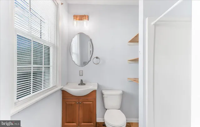 a bathroom with a toilet a sink and mirror