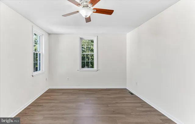 wooden floor in an empty room with a window
