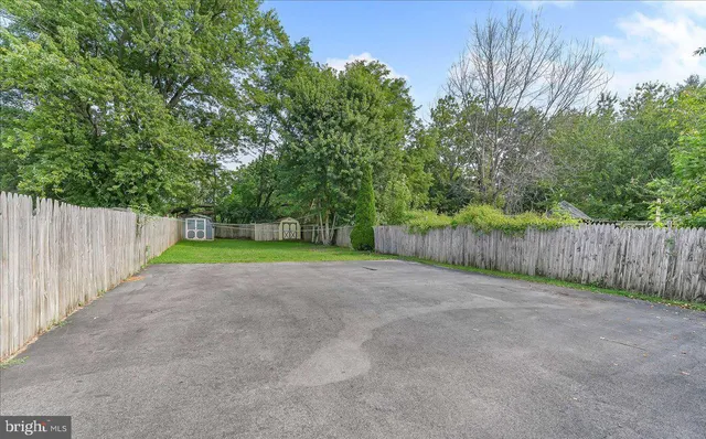 a view of a yard with wooden fence