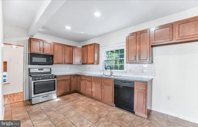 a kitchen with stainless steel appliances granite countertop a stove sink and cabinets