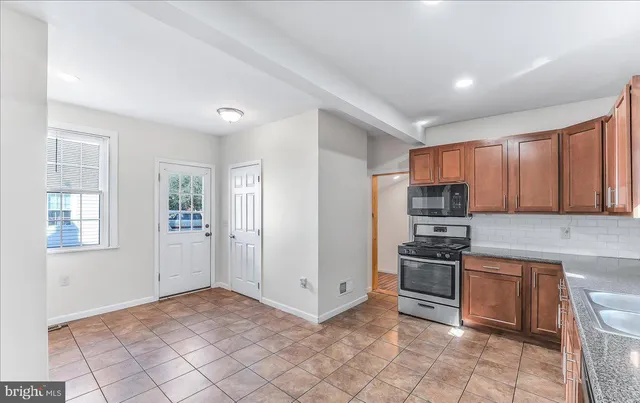 a kitchen with stainless steel appliances granite countertop a stove a sink and a refrigerator