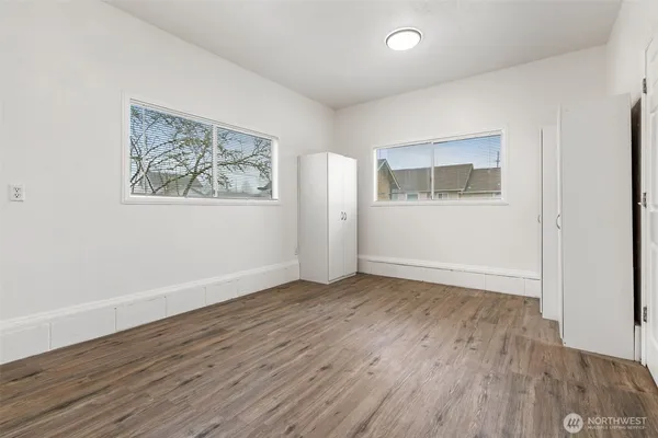 an empty room with wooden floor and window