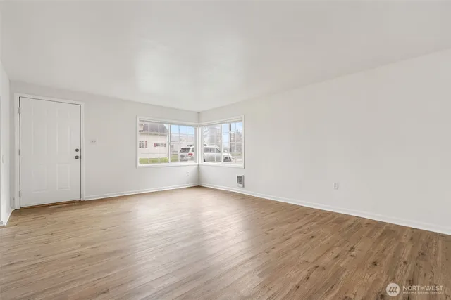 a view of a kitchen with wooden floor and windows