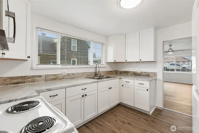 a kitchen with granite countertop white cabinets and a sink