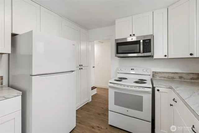 a kitchen with stainless steel appliances white cabinets and a refrigerator