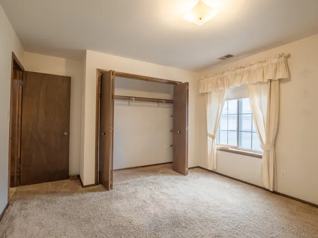 an empty room with windows and closet