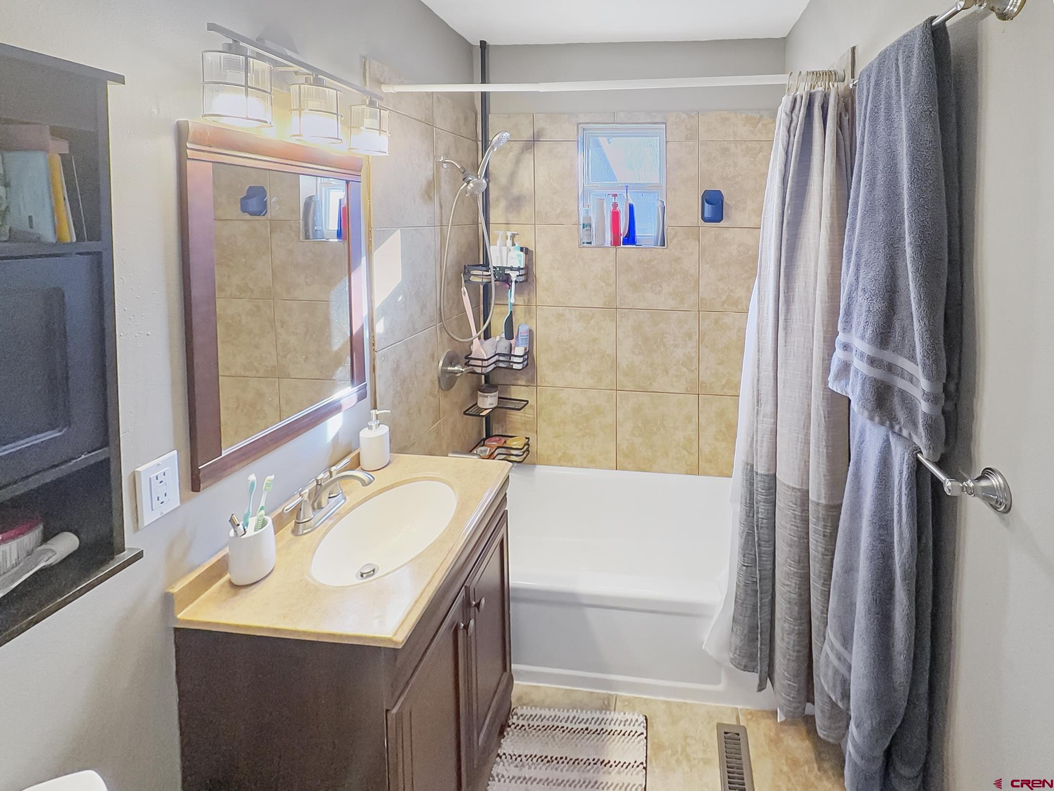 717 East 3rd Street Cortez, CO 81321 - Photo 15 of 26 a bathroom with a sink a mirror a bathtub and shower