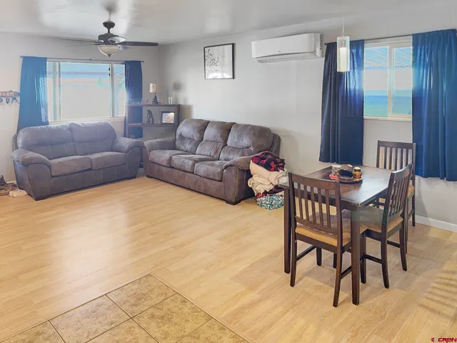 a living room with furniture and a dining table