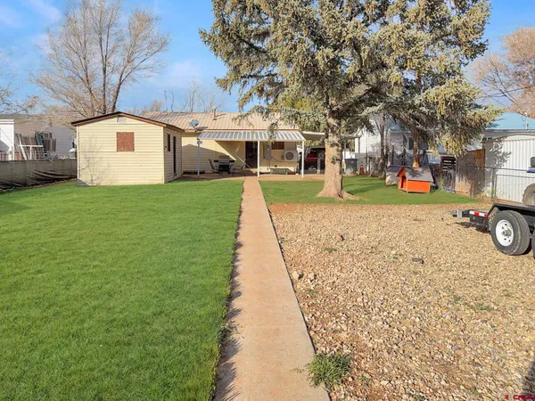 a front view of a house with a yard and trees