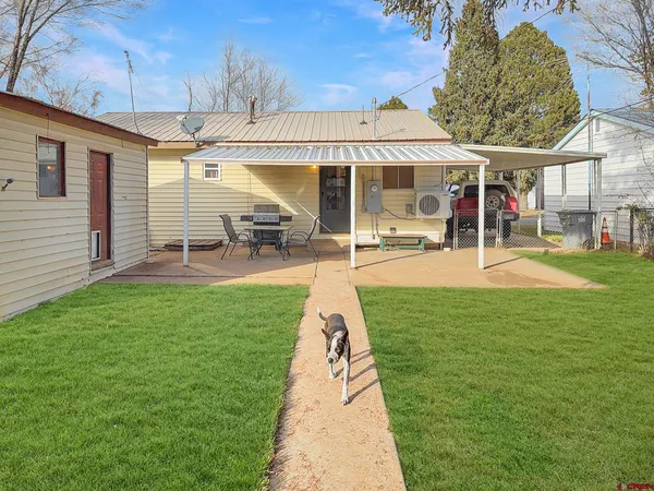 a backyard of a house with table and chairs