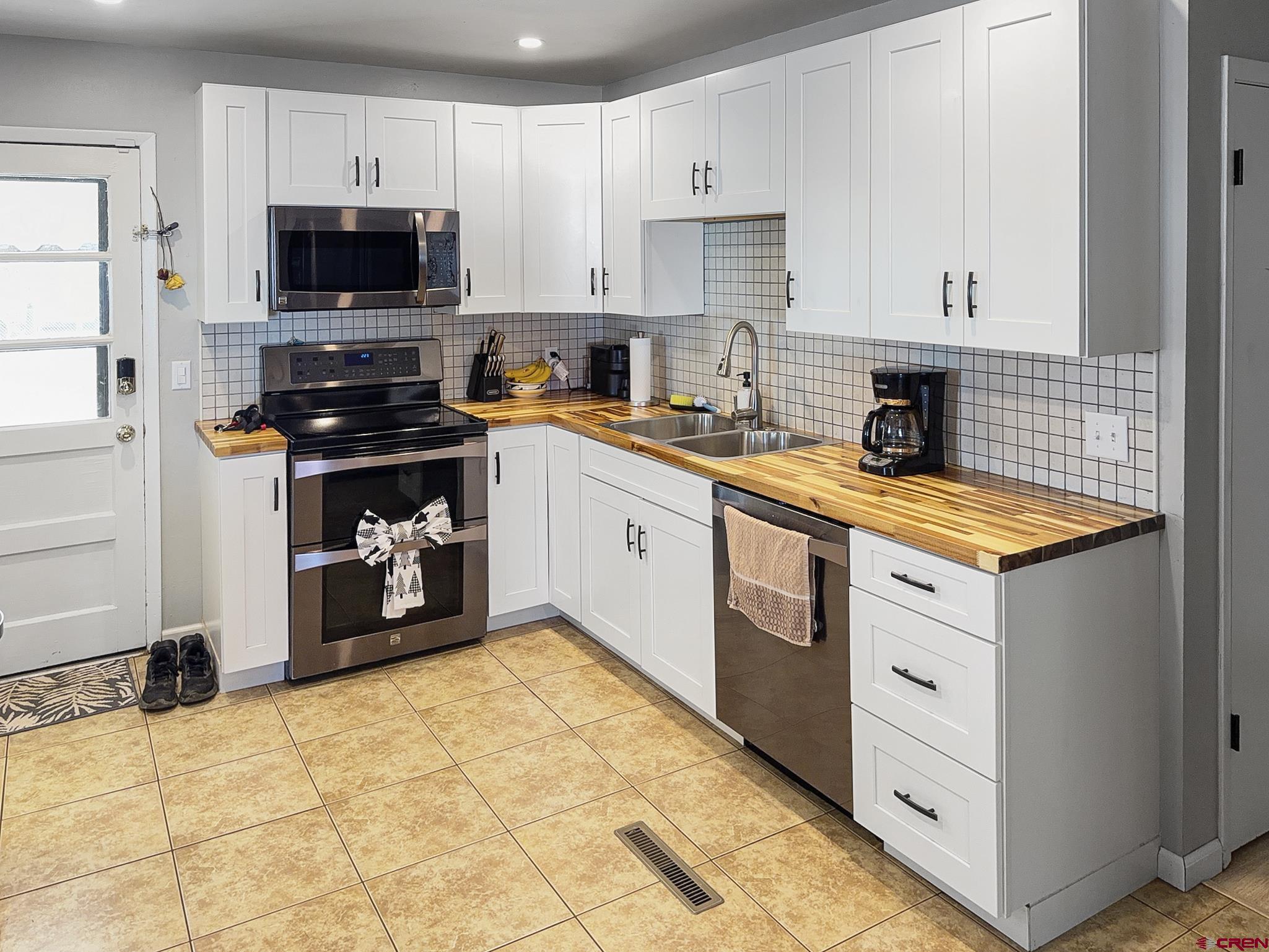 717 East 3rd Street Cortez, CO 81321 - Photo 6 of 26 a kitchen with stainless steel appliances a stove a sink a microwave and cabinets