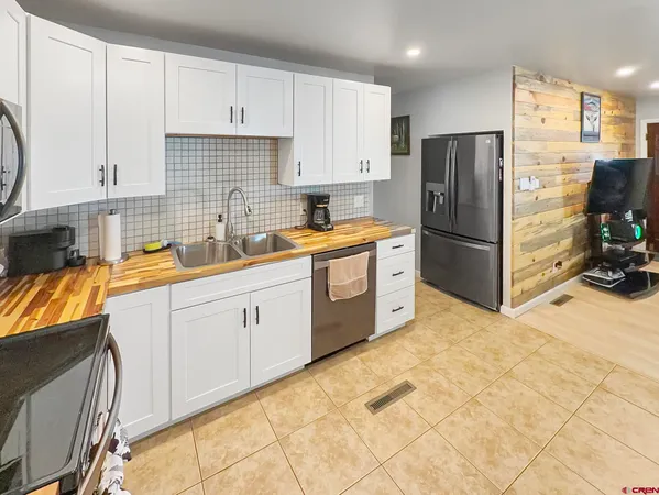 a kitchen with stainless steel appliances a refrigerator sink and cabinets