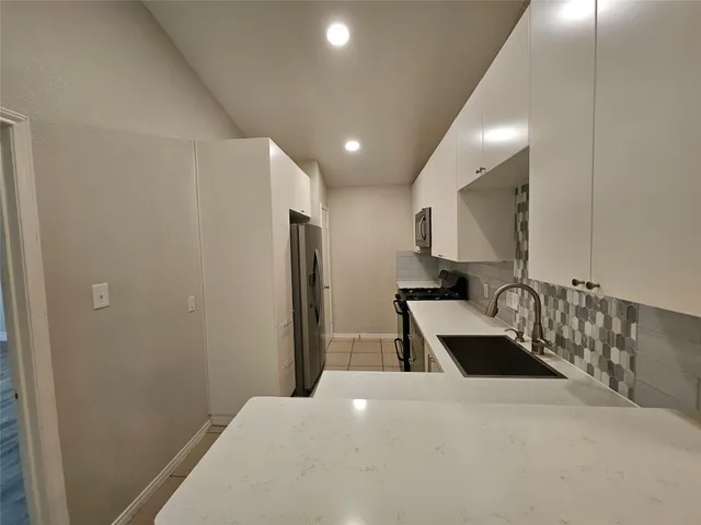 a kitchen with granite countertop a refrigerator and a sink