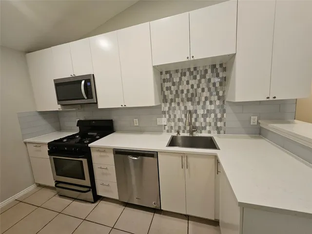 a kitchen with a sink stove and cabinets
