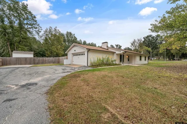 a front view of house with yard and trees around