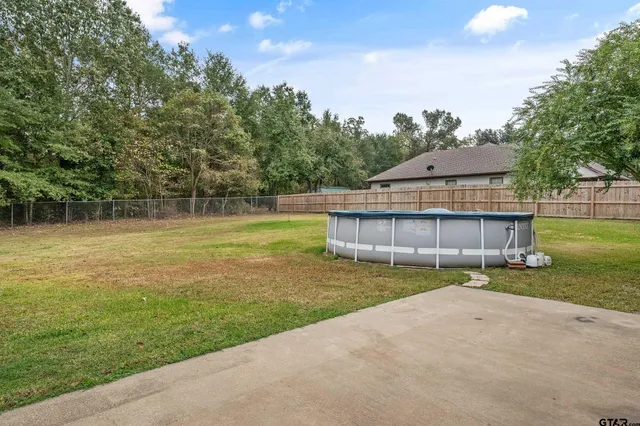 a view of a house with a yard and a basket ball court