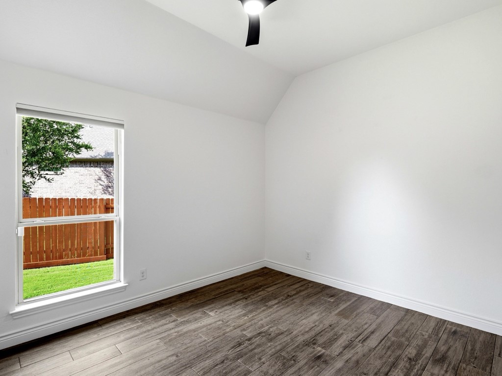 109 Lake Spring Circle Georgetown, TX 78633 - Photo 22 of 38 A well-lit master bedroom features durable tile wood look flooring and a view of the fenced yard.