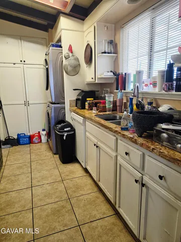 a kitchen with stainless steel appliances a sink a stove a window and cabinets