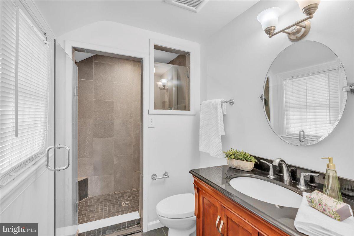 163 Welsh Road Huntingdon Valley, PA 19006 - Photo 23 of 27 a bathroom with a granite countertop sink a toilet a mirror and shower