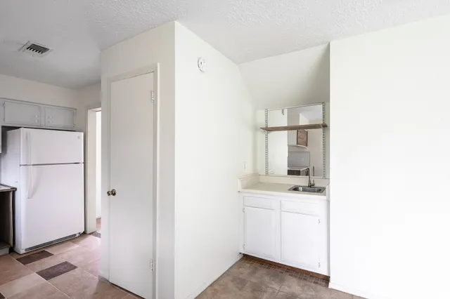 a view of kitchen with white cabinets