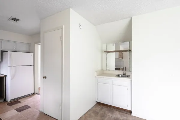 a view of kitchen with white cabinets