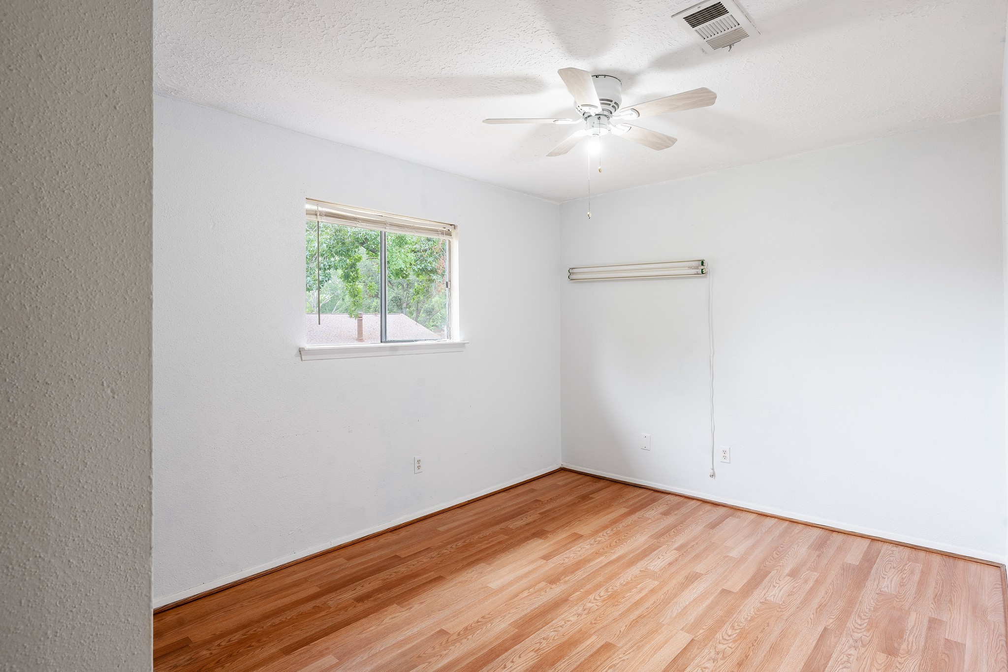 4423 Mossygate Drive Spring, TX 77373 - Photo 20 of 38 an empty room with wooden floor fan and windows