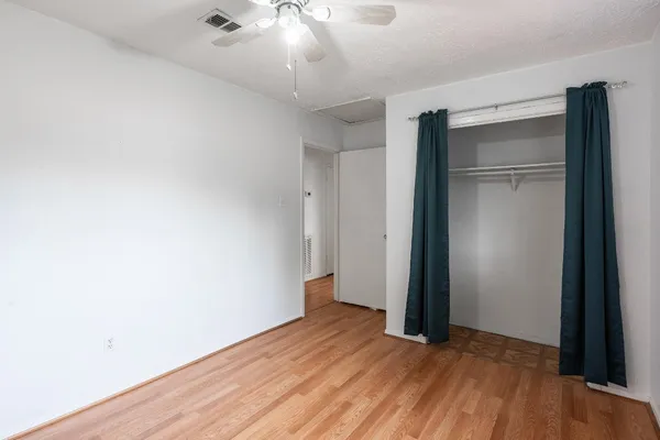 an empty room with wooden floor and closet