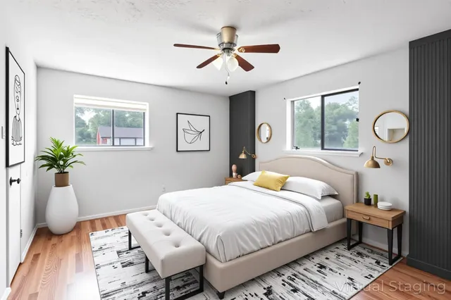 a bedroom with a bed and dresser with wooden floor