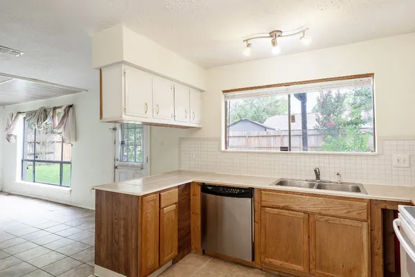 a kitchen with wooden cabinets a sink and a window