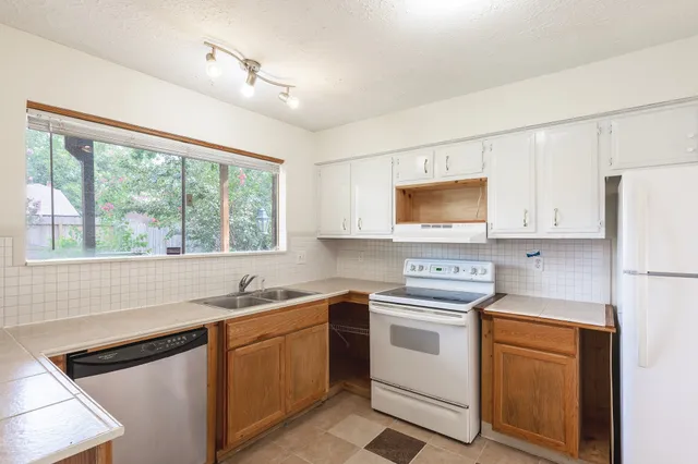 a kitchen with white cabinets and white appliances
