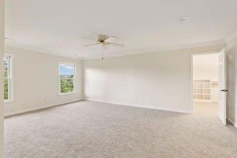 an empty room with windows and fan